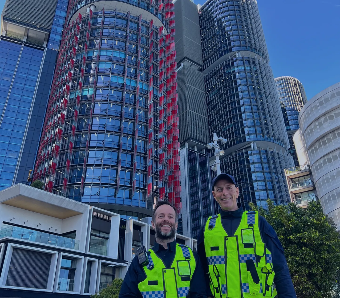 Two security officers in hi-vis vests outside Barangaroo office towers